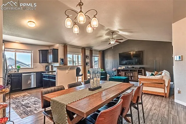 a view of a dining room with furniture a chandelier and wooden floor