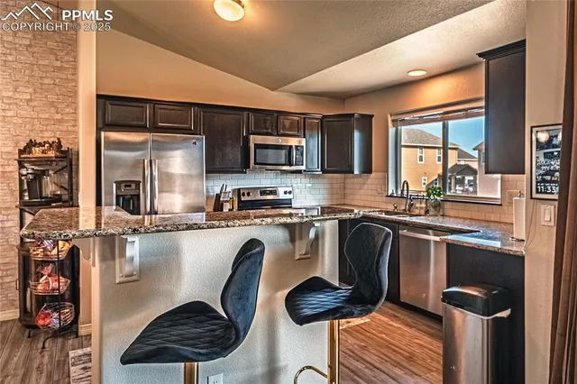 a kitchen with stainless steel appliances granite countertop a stove refrigerator sink and cabinets