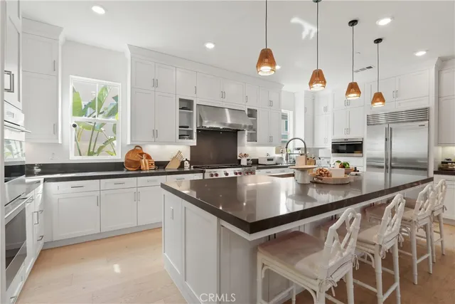 a kitchen with stainless steel appliances granite countertop a sink a stove and a center island