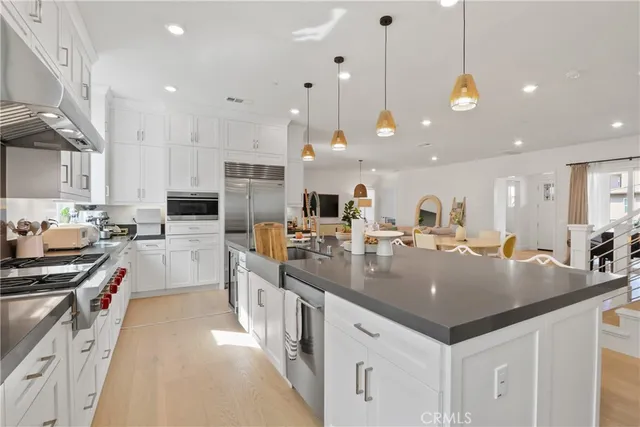 a kitchen with stainless steel appliances granite countertop a sink a stove and a wooden floors