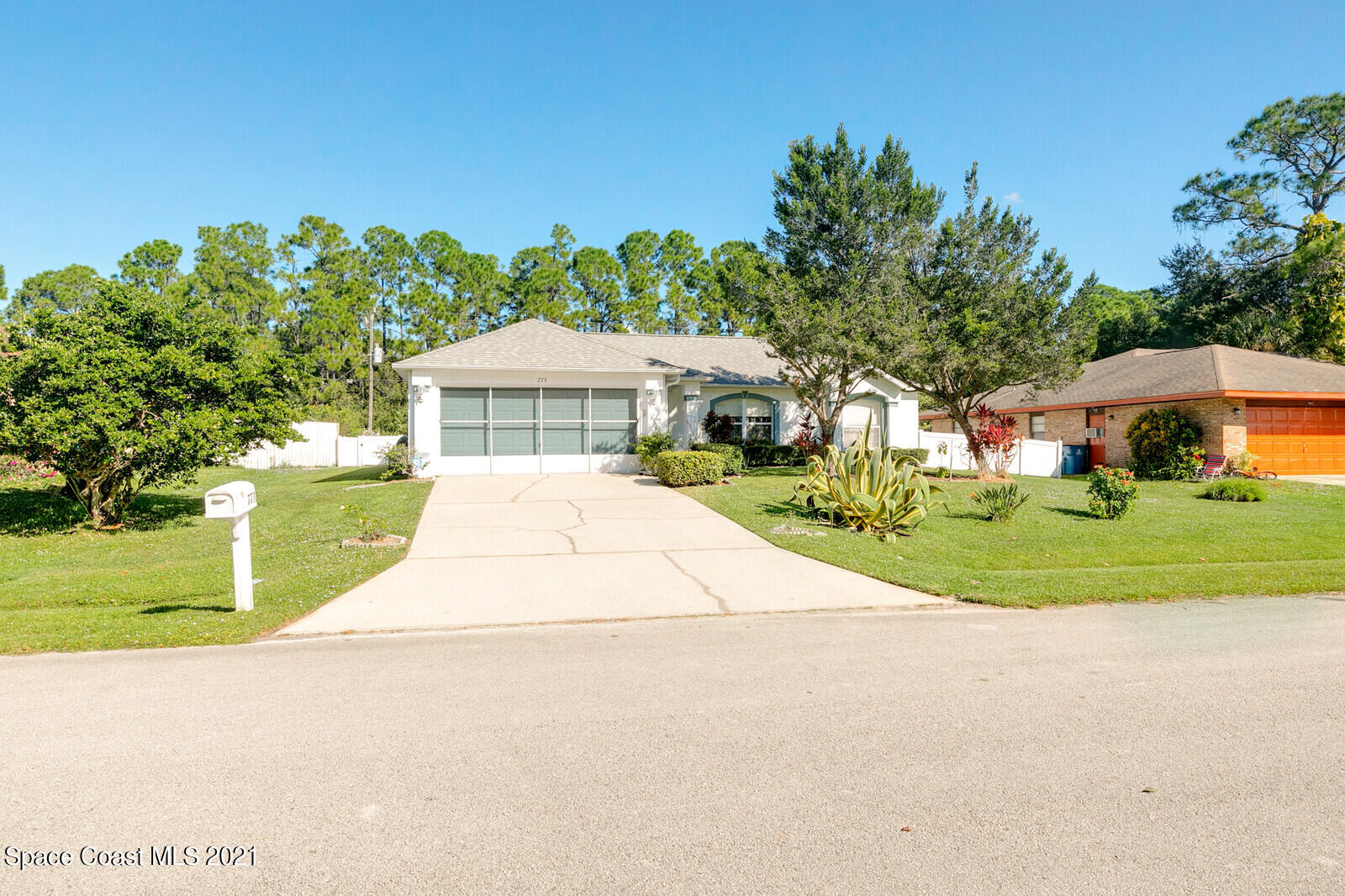 773 Furth Road Northwest Palm Bay, FL 32907 - Photo 2 of 29 a view of a white house with a yard plants and a large tree