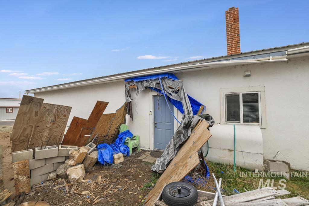315 Wilson Street Eden, ID 83325 - Photo 23 of 30 Rear view of house with stucco siding, heating fuel, and a chimney