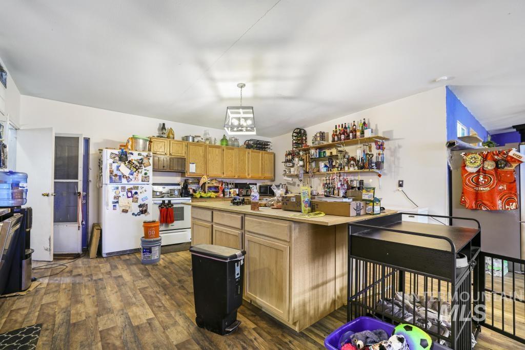 315 Wilson Street Eden, ID 83325 - Photo 4 of 30 Kitchen featuring dark wood-style floors, white appliances, light countertops, open shelves, and decorative light fixtures