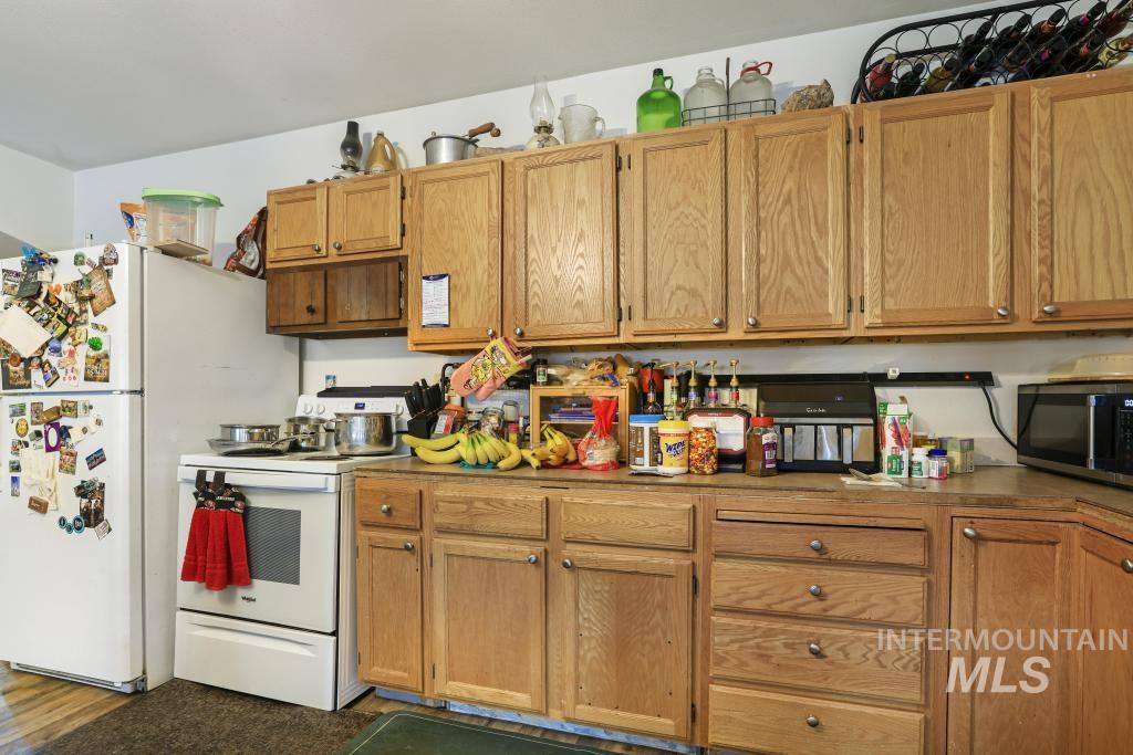 315 Wilson Street Eden, ID 83325 - Photo 6 of 30 Kitchen with white appliances and wood finish cabinets
