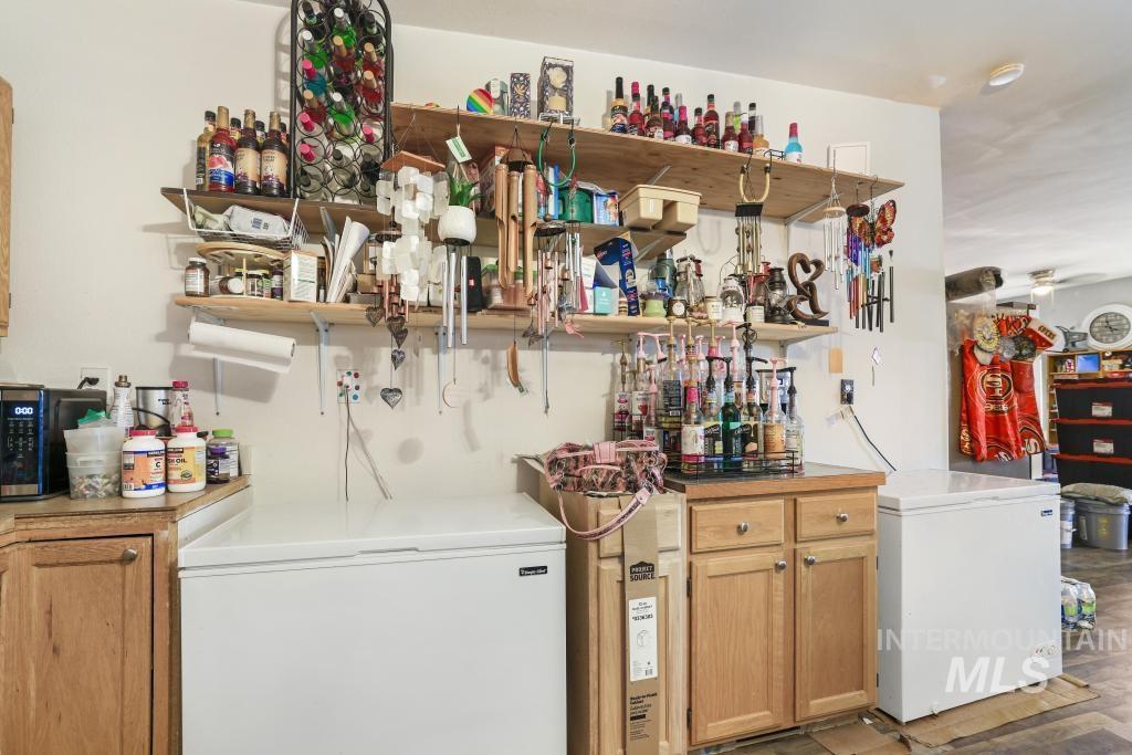 315 Wilson Street Eden, ID 83325 - Photo 8 of 30 Bar with open shelves, light countertops, black microwave, and light wood finish cabinetry
