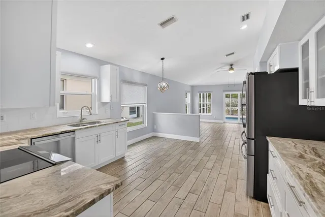 a kitchen with stainless steel appliances granite countertop a refrigerator a stove top oven a sink and dishwasher