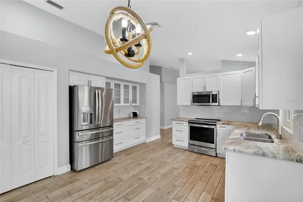a kitchen with counter top space stainless steel appliances and wooden floor