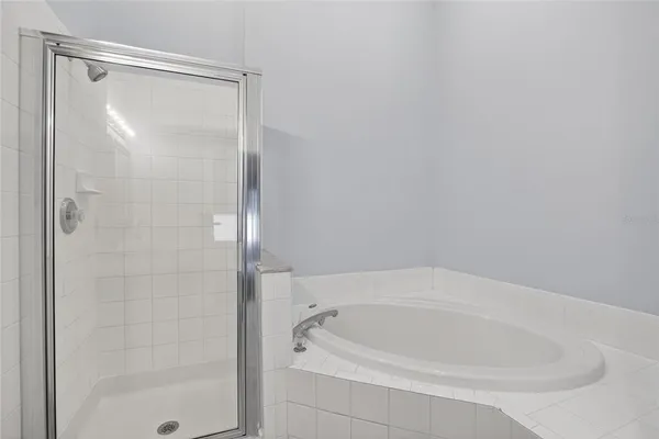 an empty room with a chandelier fan and closet area