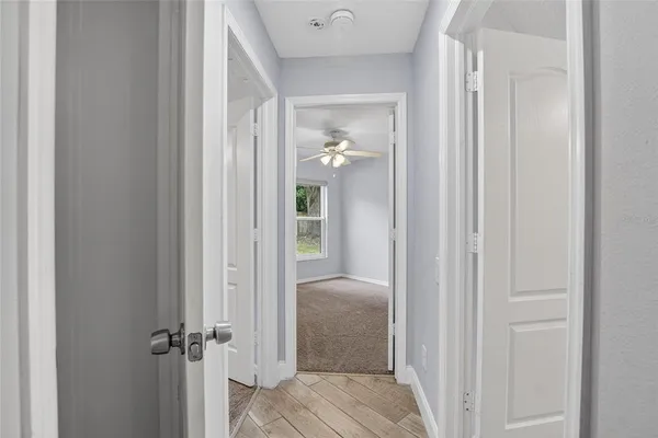 an empty room with a ceiling fan and a window