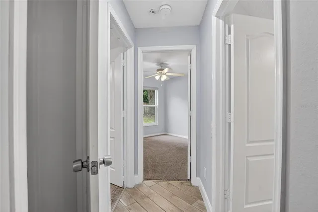 an empty room with a ceiling fan and a window