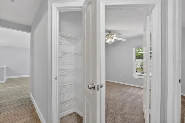 an empty room with a window and a fan