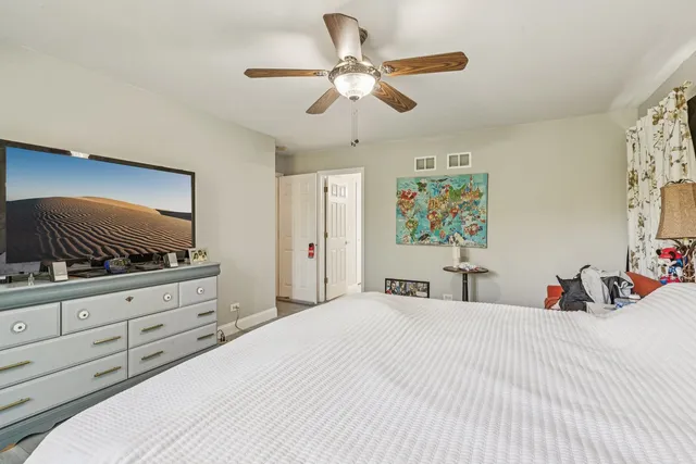 a bedroom with a large bed and a flat tv screen on dresser