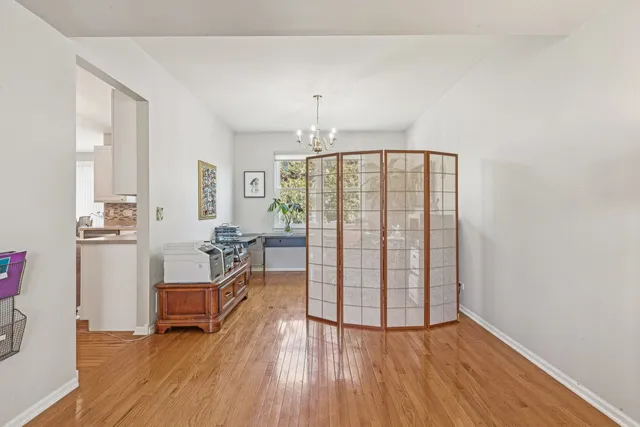 a view of front door with hallway and wooden floor