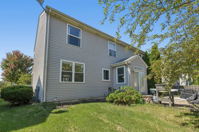 a view of backyard with table and chairs and potted plants