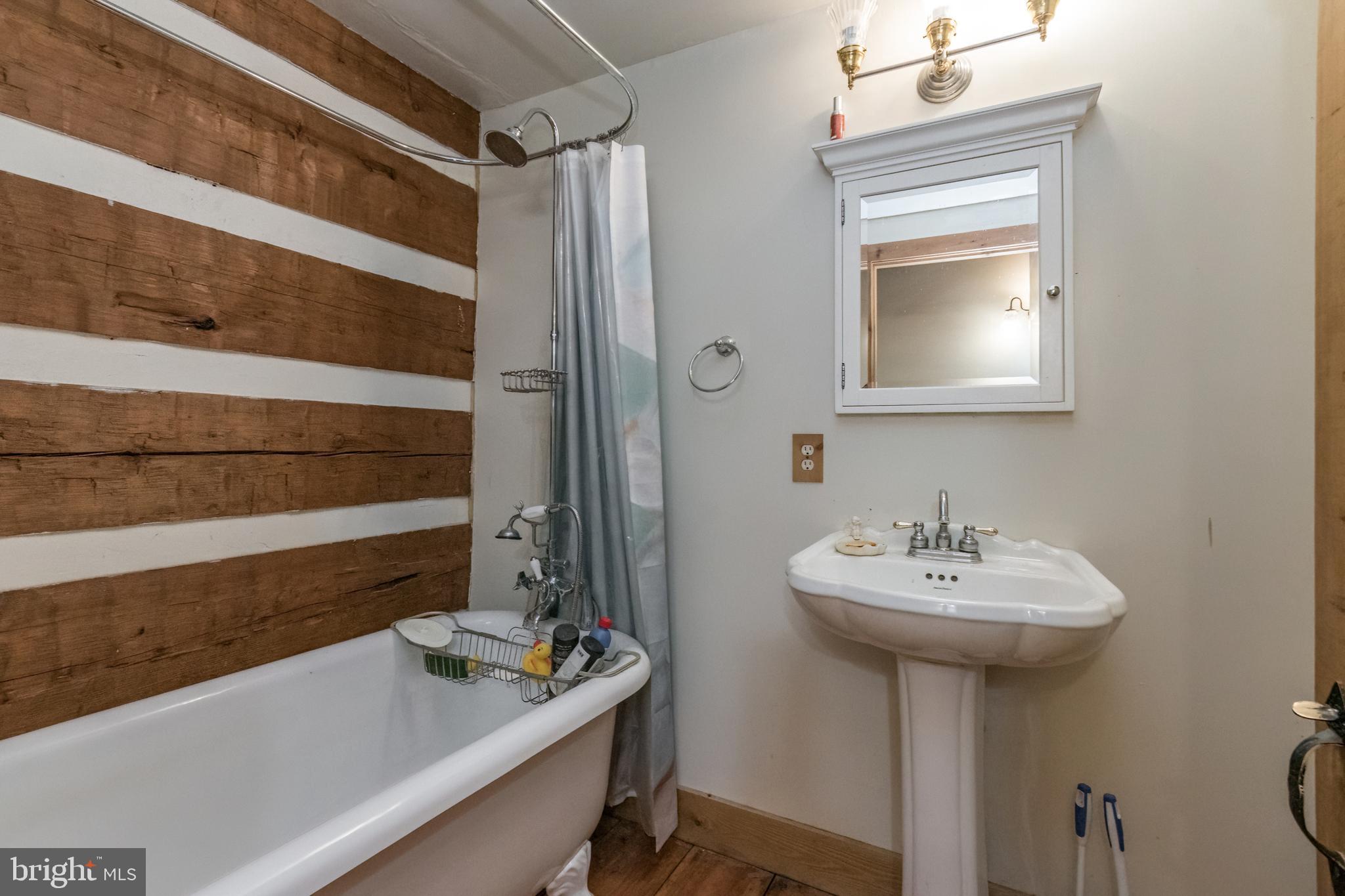 Primary bath has claw foot tub with bubbles
