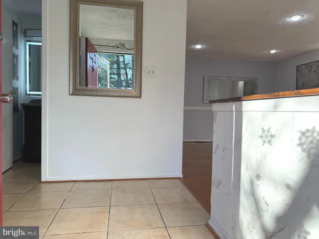 a view of empty room with wooden floor and windows