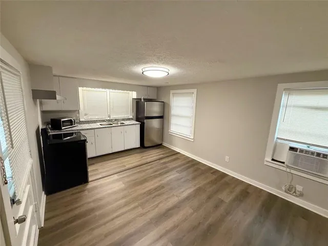 a kitchen with granite countertop a refrigerator stove and sink