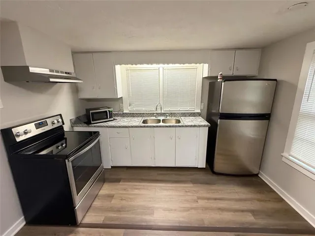 a kitchen with a refrigerator a stove a microwave and cabinets
