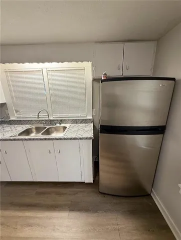 a view of an empty room with wooden floor and closet