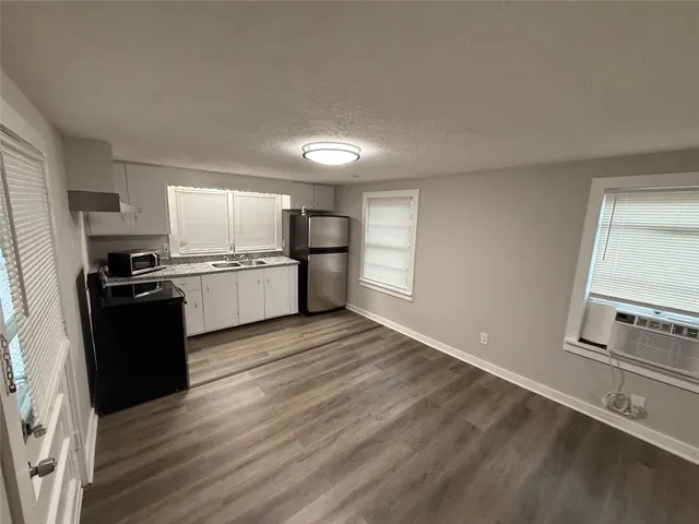 a kitchen with granite countertop a refrigerator stove and sink