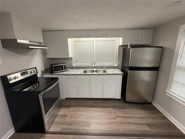 a kitchen with a refrigerator a stove a microwave and cabinets
