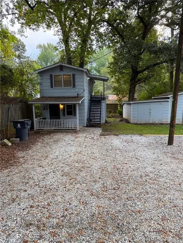 a view of a house with a yard and large tree