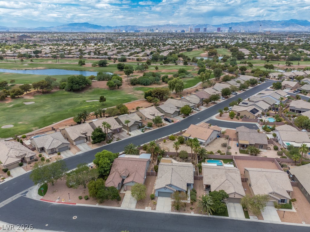 3591 Driving Range Street Las Vegas, NV 89122 - Photo 13 of 79 An aerial perspective reveals a residential community bordering a lush golf course with distant city views.