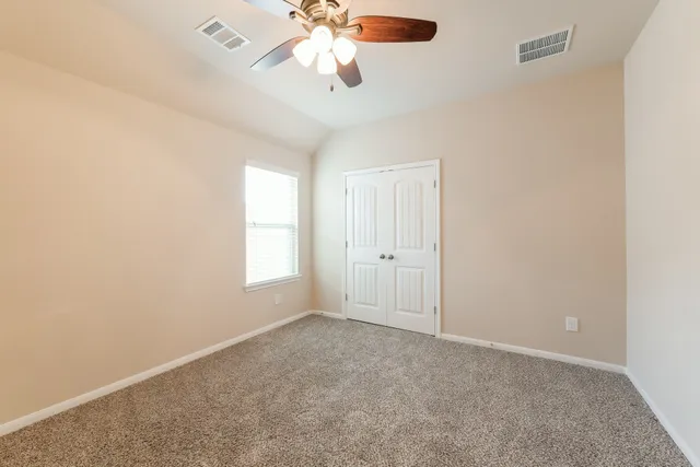 an empty room with windows and fan