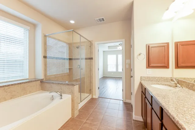 a spacious bathroom with a tub sink and mirror