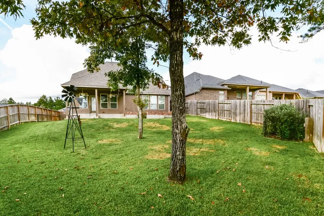a view of a house with a backyard and a tree
