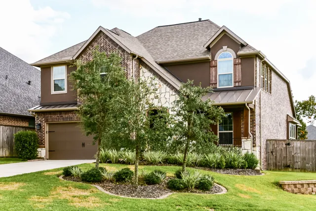 a front view of a house with a yard and potted plants