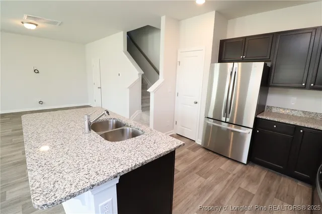 a kitchen with stainless steel appliances granite countertop a refrigerator a sink a stove and island