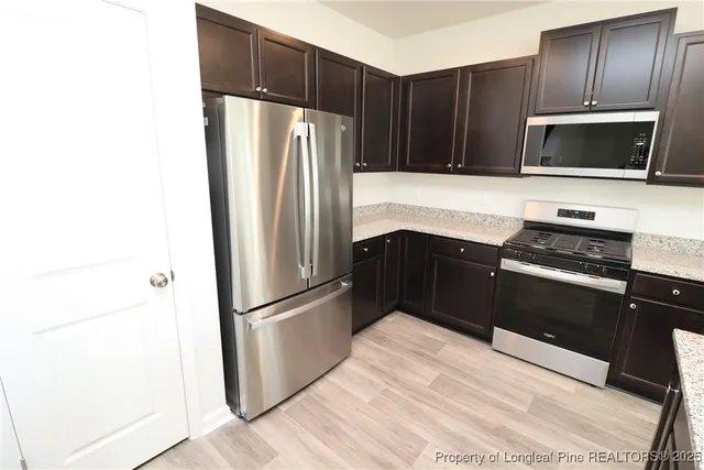 a kitchen with granite countertop stainless steel appliances and wooden cabinets