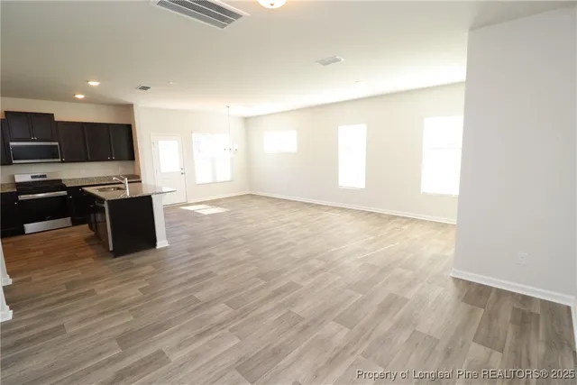 a view of a kitchen with wooden floor and a sink