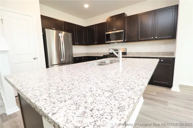 a kitchen with kitchen island granite countertop wooden cabinets and a granite counter top