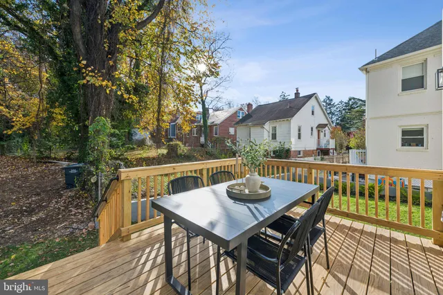 a view of a patio with table and chairs with wooden floor and fence