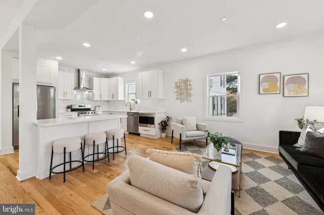 a living room with stainless steel appliances kitchen island granite countertop furniture and a view of kitchen