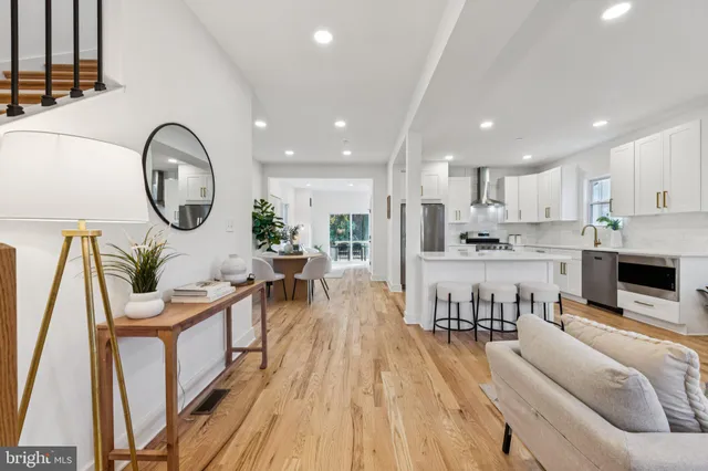 a living room with furniture a clock and wooden floor