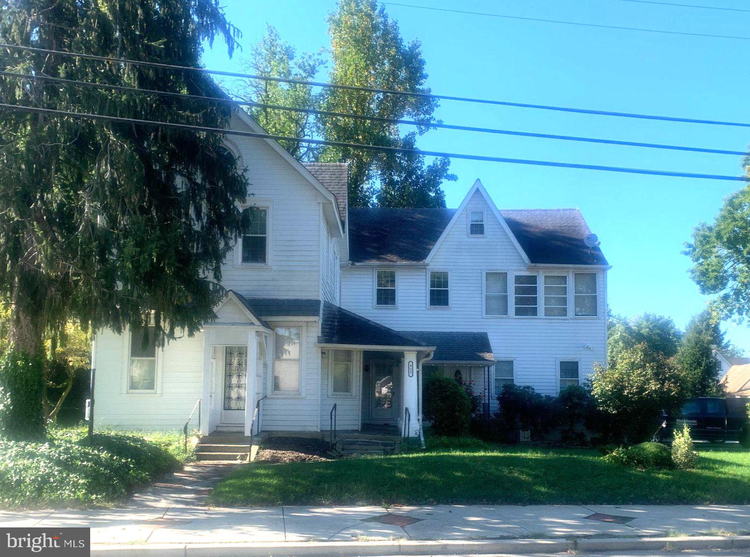 a front view of a house with a yard and potted plants