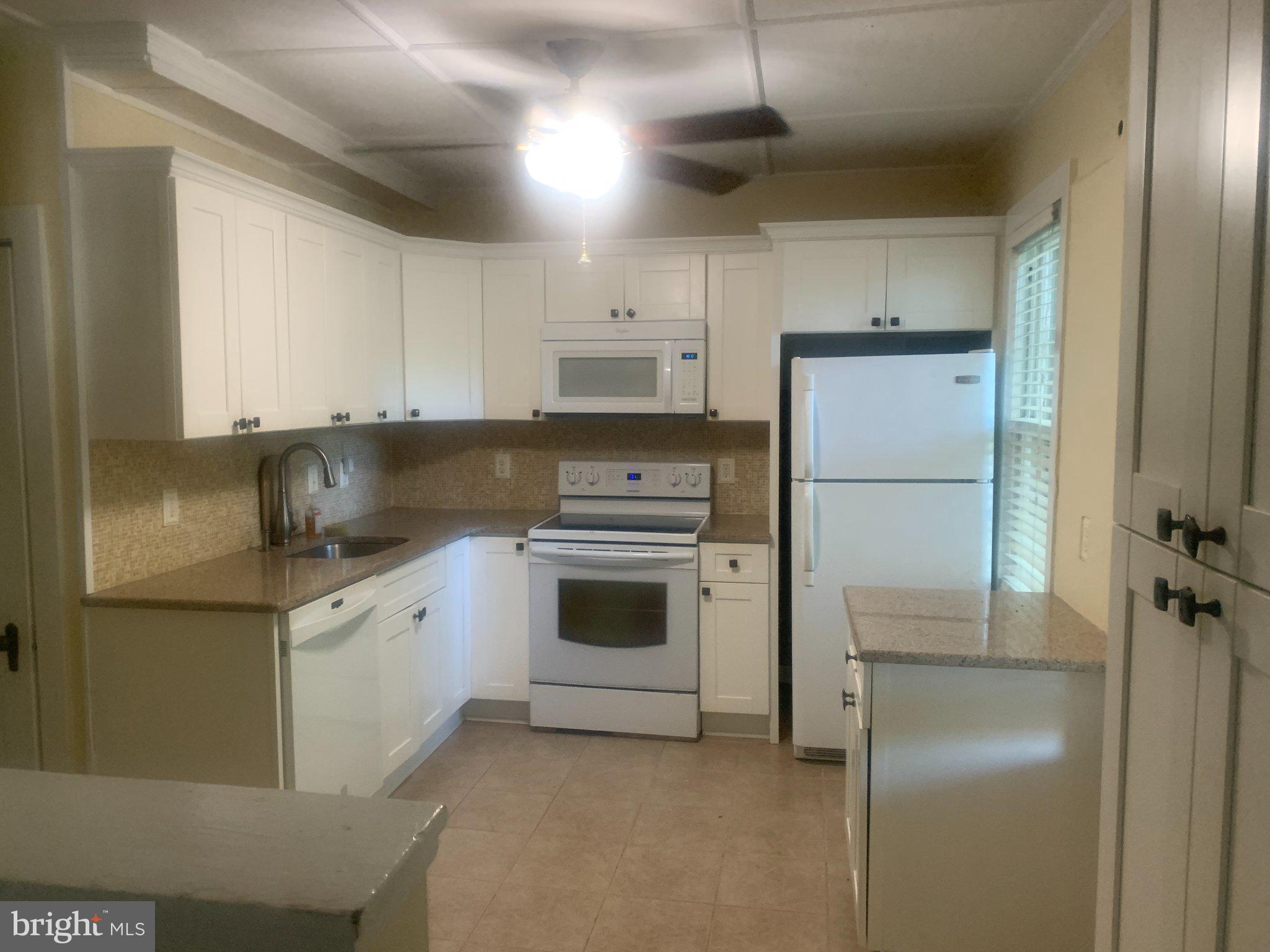 915 Stone Road, Unit A Laurel Springs, NJ 08021 - Photo 3 of 13 a kitchen with stainless steel appliances granite countertop a refrigerator a stove and a sink