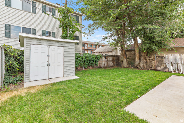 369 200 North Provo, UT 84601 - Photo 14 of 32 Expansive grassy yard area featuring a storage shed with double doors, mature trees, and concrete paving. Unit 371. 2 bed 1 bath