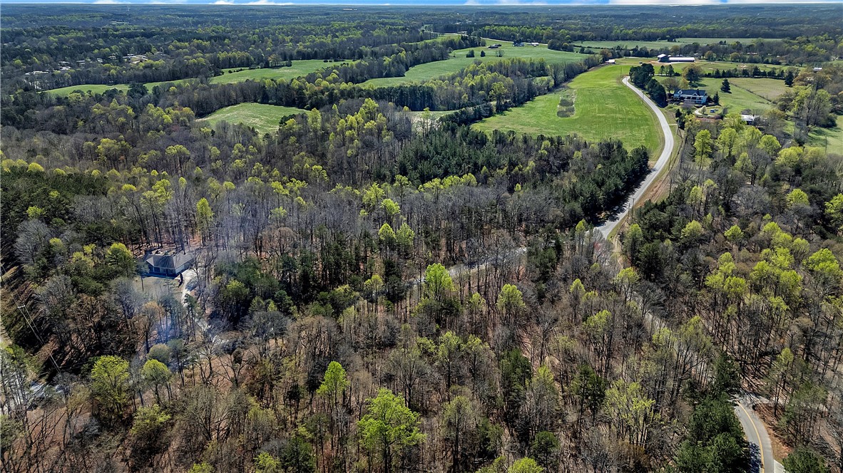 3.271 Coneross Point Drive Seneca, SC 29678 - Photo 4 of 9 This expansive aerial view showcases a lush landscape with verdant trees and open fields.