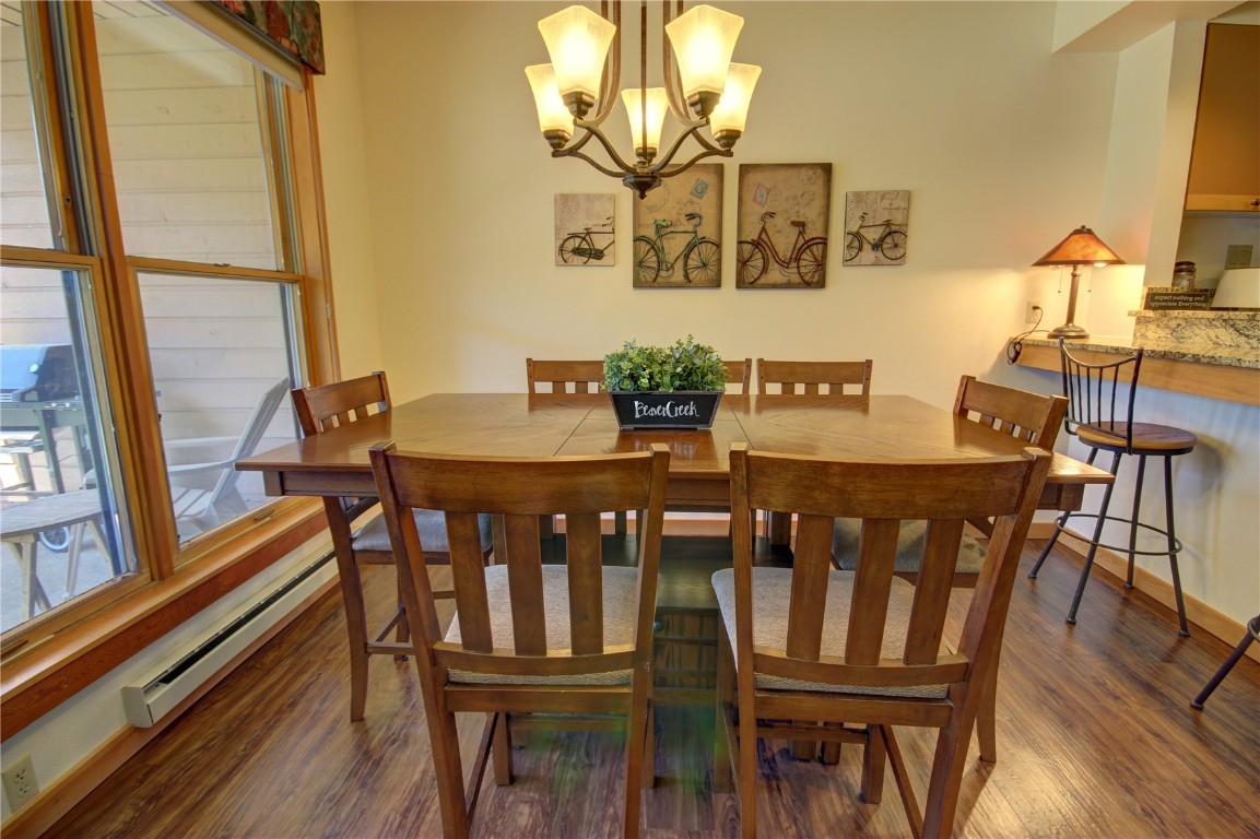 Dining room with plenty of natural light, a notable chandelier, and dark hardwood / wood-style flooring