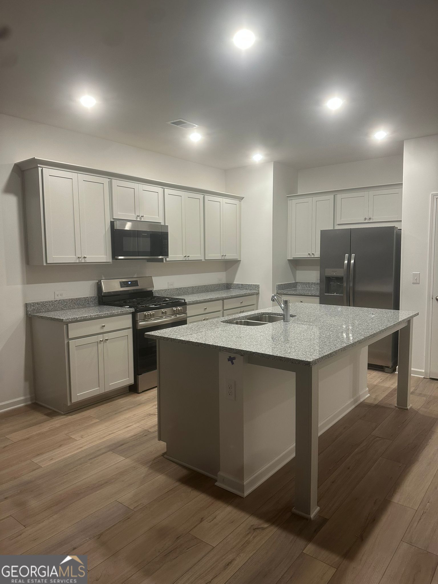4281 Marsha Street Doraville, GA 30360 - Photo 26 of 38 a kitchen with stainless steel appliances a sink a stove a microwave a center island and a refrigerator