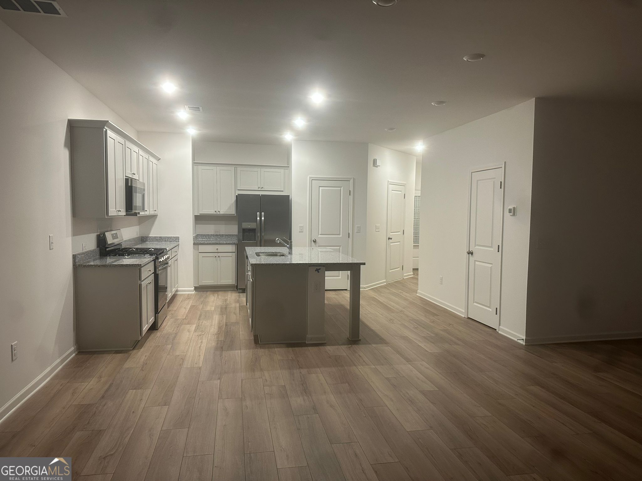 4281 Marsha Street Doraville, GA 30360 - Photo 27 of 38 a large kitchen with kitchen island a sink dishwasher a refrigerator and cabinets with wooden floor