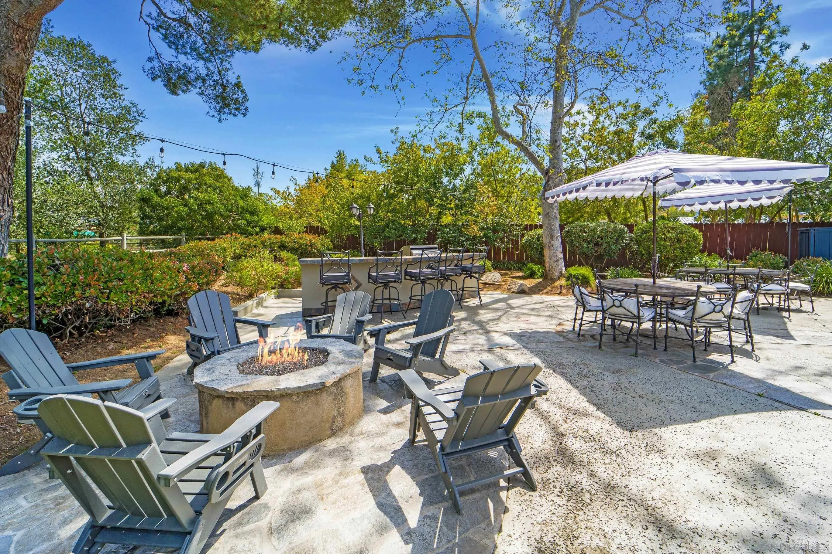 16163 Del Norte Poway, CA 92064 - Photo 32 of 41 a view of a patio with a dining table and chairs under an umbrella with a barbeque