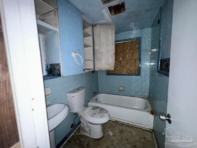 a bathroom with a glass shower door and a window