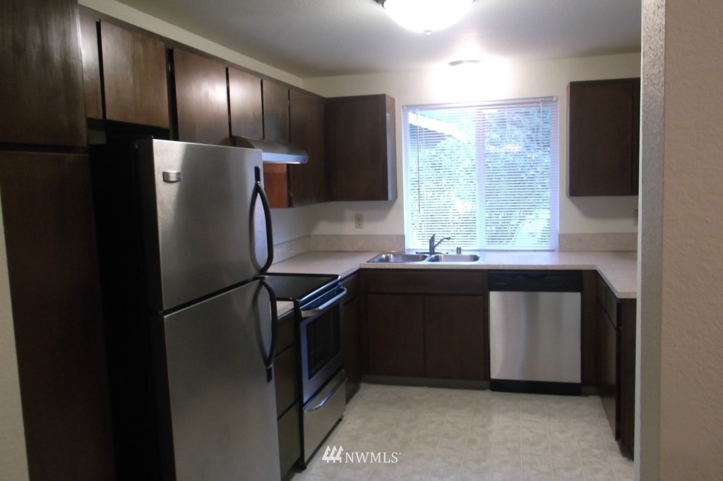 5116 Parker Road East Sumner, WA 98390 - Photo 4 of 8 a kitchen with stainless steel appliances granite countertop a refrigerator and a sink