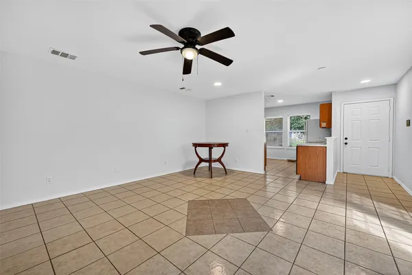 a view of a livingroom with a dinning area a ceiling fan and wooden floor