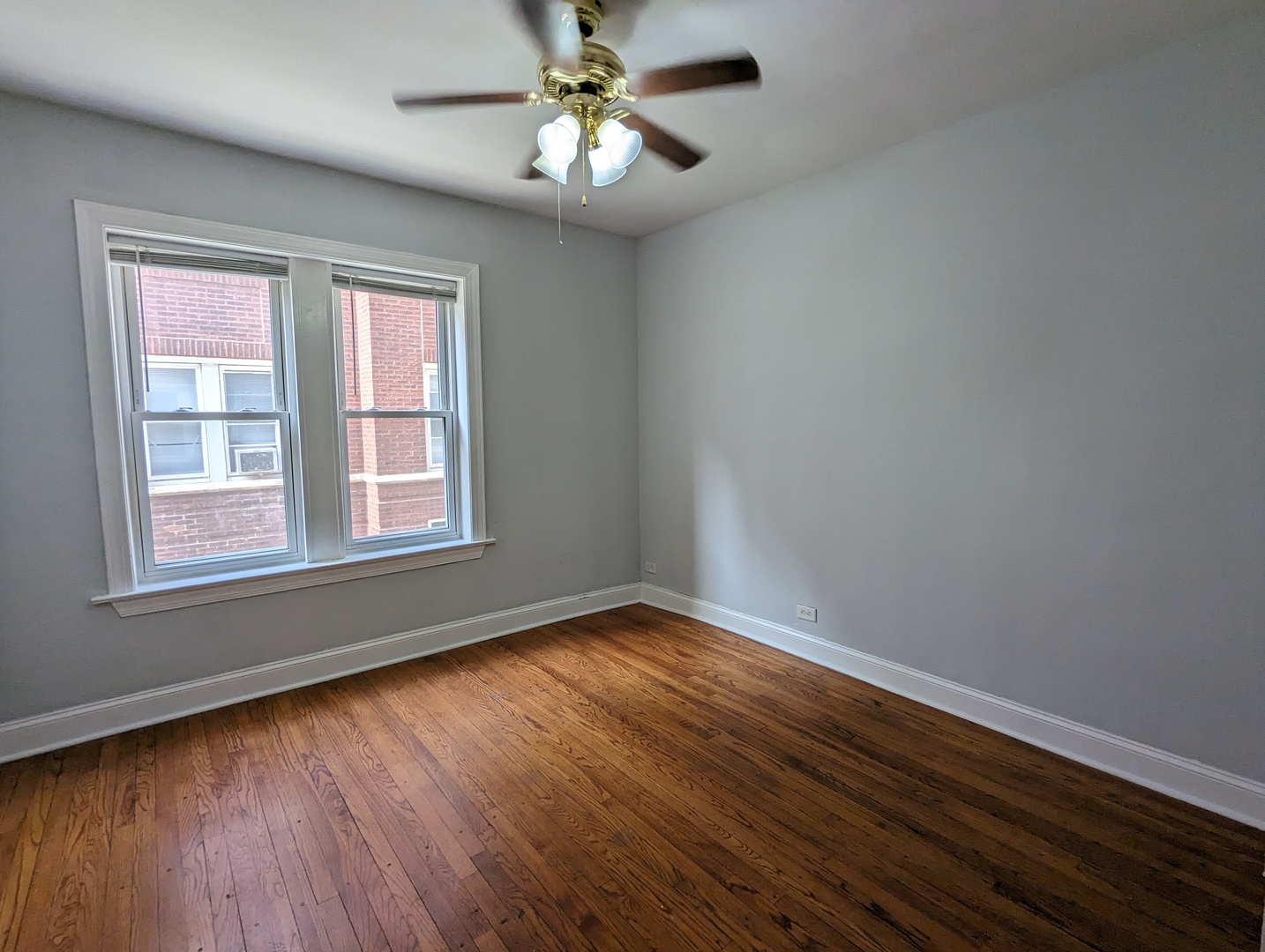5029 North Harding Avenue, Unit 1W Chicago, IL 60625 - Photo 17 of 18 a view of an empty room with wooden floor and a window
